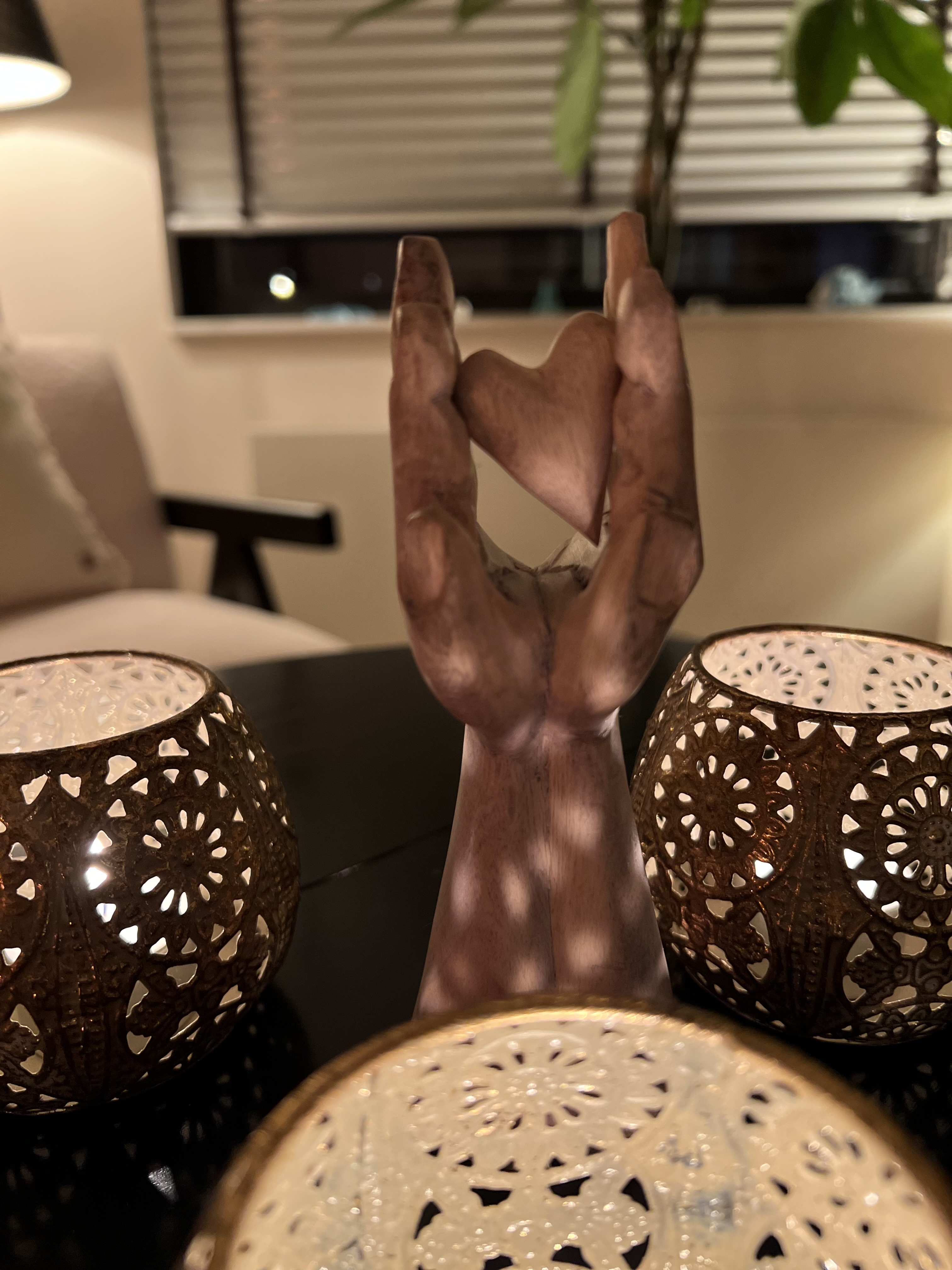 Houten hand met een hart tussen sfeerlichtjes